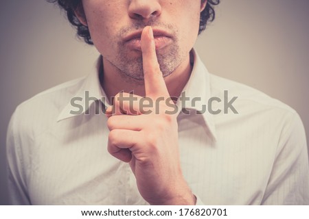 stock-photo-young-man-with-finger-on-lips-is-gesturing-hush-176820701.jpg