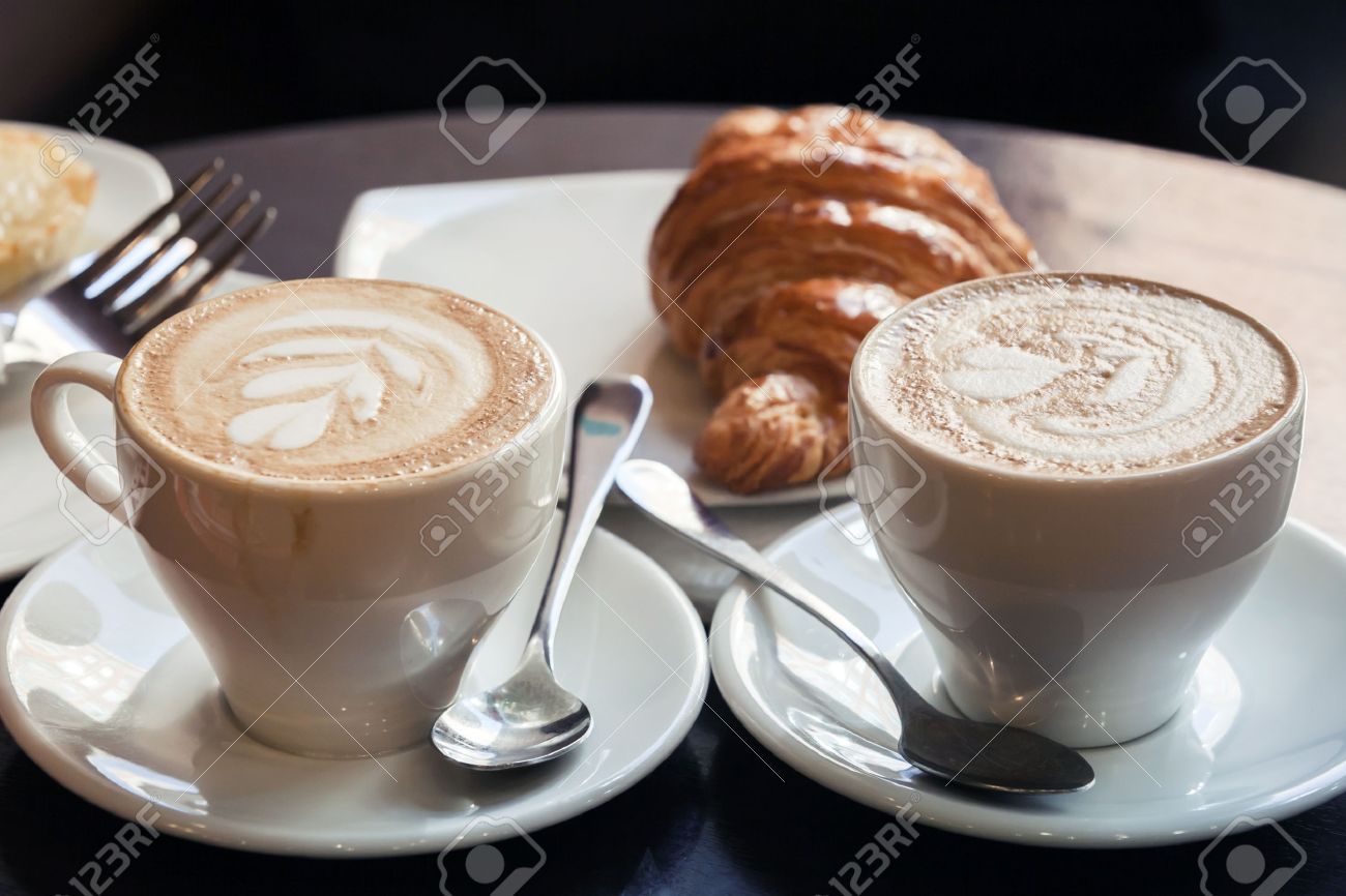40871617-cappuccino-with-croissant-two-cups-of-coffee-with-milk-foam-stands-on-a-table-in-cafeteria-vintage-t.jpg